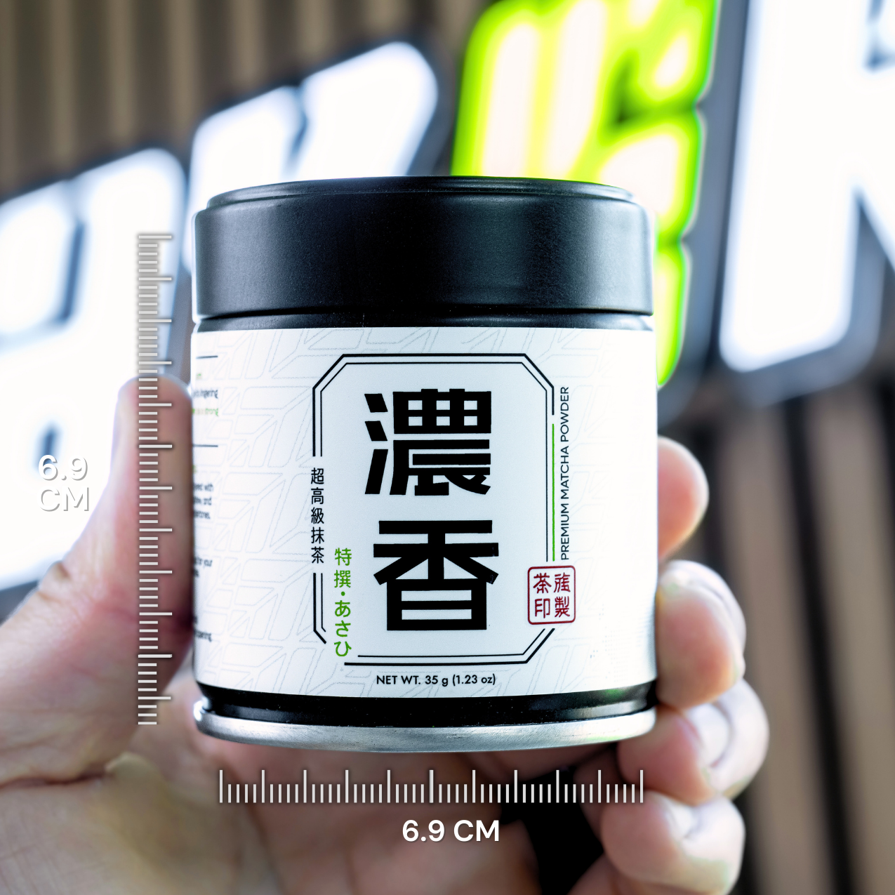 Jar of matcha powder held by a hand with measurement scale