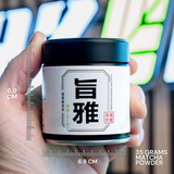 Hand holding a container of matcha powder with measurement details